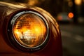 Vintage car headlights with beautiful blurred bokeh effect of colorful sunset in the background Royalty Free Stock Photo