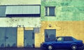 Vintage car standing by wall of shabby house