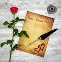 Vintage card with red rose, painted harts, ink and quill on white painted oak - top view Royalty Free Stock Photo