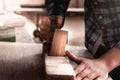 Vintage carpenter working on wood using wood retro vintage old ancient planer. Workshop background