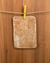 Vintage carton tag, paper for note, label for your text or design with clothespin and a rope on a wooden background