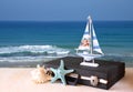 Vintage case with old boat toy and starfish in front of seascape. travel concept