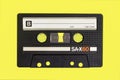 Vintage cassette tape isolated. Black audio cassette B side on yellow background. Royalty Free Stock Photo