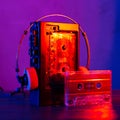 Vintage cassette tape player in neon light. 80s - 90s advertisement style. Disco party nostalgy concept