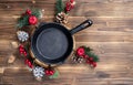 Vintage cast iron skillet on rustic wood background. Food background with copyspace. New Year and Christmas menu in a Royalty Free Stock Photo