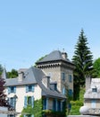 Vintage castle like houses with blue shuttered windows and vivid greenery in Arreau, France