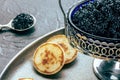 Vintage caviar dish with black caviar and blinis, a closeup on black