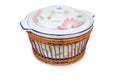 Vintage ceramic tureen in wooden basket on a white background