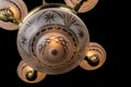 Vintage chandelier on black background, bronze antique chandelier with burning light, bottom view of an antique bronze chandelier Royalty Free Stock Photo