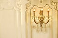 Vintage chandelier sconce lamp with candle lights on light wall Royalty Free Stock Photo