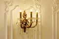 Vintage chandelier sconce lamp with candle lights on light wall Royalty Free Stock Photo