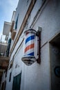 Vintage Charm: Barber Shop Pole Adorning Old White Building Wall