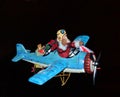 Vintage Christmas decoration of Santa Claus piloting a blue airplane. Isolated on black
