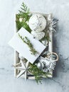 Vintage Christmas Decorations, gift box and Evstmas Decorations and Evergreen Twigs on a rustic wooden tray. Flatlay. Copy space Royalty Free Stock Photo