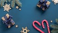 Vintage Christmas holiday composition. Flat lay gift boxes, candy canes, wooden decorations, Xmas tree branches on dark blue Royalty Free Stock Photo