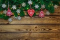 Christmas holidays background with fir tree branches and snowflokes over wooden planks