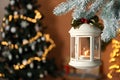 Vintage Christmas lantern with burning candle hanging on fir branch against blurred background. Space for text Royalty Free Stock Photo