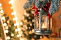 Vintage Christmas lantern with burning candle hanging on fir branch against blurred background. Space for text Royalty Free Stock Photo