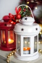 Vintage Christmas Lanterns Red and White with burning Candles. Cozy christmas decorations with golden beads, balls. Christmas tree Royalty Free Stock Photo
