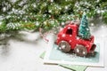 Vintage Christmas red car ornament on paper slips and fir tree branches placed on white textured background and fir tree with snow Royalty Free Stock Photo