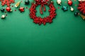 Vintage Christmas table with red wreath, balls, stars, confetti on green background. Flat lay, top view Royalty Free Stock Photo