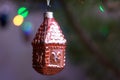 Vintage christmas tree toy house of glass on pine at night with lights closeup Royalty Free Stock Photo