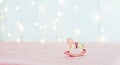 Vintage Christmas tree toy porcelain figurine of a rocking horse standing on the pink tablecloth against the background of blurred Royalty Free Stock Photo