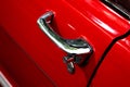 Vintage chromed handle of a red car with a lock. Vehicle. Driver`s door. Royalty Free Stock Photo