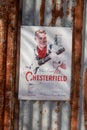 Vintage cigarette poster advertising Chesterfield mounted on rusty corrugated iron. Image taken in mobile format