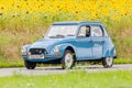 Vintage Citroen 2CV in front of a field with blooming sunflowers Royalty Free Stock Photo