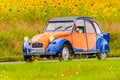 Vintage Citroen 2CV in front of a field with blooming sunflowers Royalty Free Stock Photo