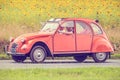 Vintage Citroen 2CV in front of a field with blooming sunflowers Royalty Free Stock Photo