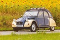 Vintage Citroen 2CV in front of a field with blooming sunflowers Royalty Free Stock Photo