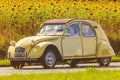 Vintage Citroen 2CV in front of a field with blooming sunflowers Royalty Free Stock Photo