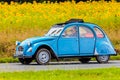 Vintage Citroen 2CV in front of a field with blooming sunflowers Royalty Free Stock Photo