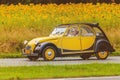 Vintage Citroen 2CV in front of a field with blooming sunflowers Royalty Free Stock Photo