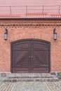 Vintage classic double-sided door in a red brick wall under a tiled roof. Cobblestone walkway and porch in front of a wooden door Royalty Free Stock Photo