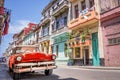Vintage classic red american car in a colorful street of Havana Cuba