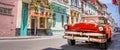 Vintage classic red american car in a colorful street of Havana Cuba. Panoramic travel web banner Royalty Free Stock Photo