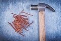 Vintage claw hammer copper construction nails on metallic backgr Royalty Free Stock Photo