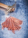 Vintage claw hammer heap of copper construction nails on scratch Royalty Free Stock Photo