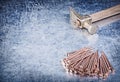 Vintage claw hammer stack of copper construction nails on metallic background Royalty Free Stock Photo