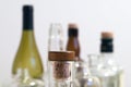 Vintage clear glass liquor bottles with cork in focus with plain