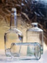 Vintage clear glass liquor bottles with one on its side with gold background