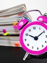 Vintage clock alarm reminder deadline in front of stack of files Royalty Free Stock Photo