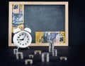 Vintage clock, blackboard, 50 australian dollars bill, and coin Royalty Free Stock Photo
