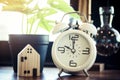 Vintage clock and little homes on the old book ,retro or vintage concept.