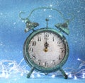Vintage clock over blue ice bokeh background. new year concept. retro filtered with glitter overlay. selective focus Royalty Free Stock Photo