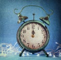 Vintage clock over blue ice bokeh background and white garland. new year concept. selective focus Royalty Free Stock Photo