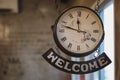 Vintage clock with roman number and welcome label hanging